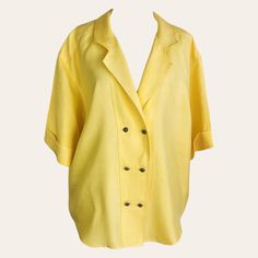 This womens stunning bright yellow double-breasted short-sleeve blouse dates back to the 1990s. The actual color is a deeper yellow than shown in the photos, as capturing the true color of clothing can be challenging. It's made from a polyester fabric with a linen-like appearance and a soft, flowing texture. A distinctive patch adorns the back panel near the center back hem, and the extended shoulders enhance the blouse's fluid silhouette. The peaked collar is integrated into the double-breasted Oversized Short Sleeve Office Blouse, Oversized Short Sleeve Blouse For Office, Vintage Solid Summer Blouse, Yellow Summer Office Shirt, Summer Blouse With Lapel Collar In Solid Color, Oversized Yellow Collared Tops, Oversized Summer Office Tops, Retro Short Sleeve Office Top, Retro Short Sleeve Top For Office