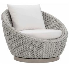 a gray wicker chair with white pillows