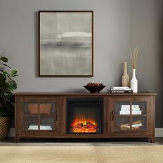 a living room with a fire place in the center and a painting on the wall