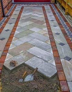 an outdoor patio with brick pavers and flagstone walkway leading up to the front door