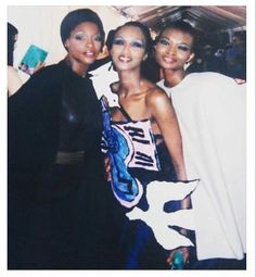 three women standing next to each other posing for a photo