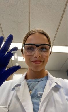 a woman in white lab coat and blue gloves