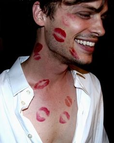 a man with red lipstick on his face and chest