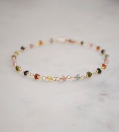 Spread creativity and joy with this multicolor gemstone Tourmaline bracelet! This handmade beauty features natural Tourmaline crystals in a variety of hues, including pink, black, green, and yellow. Each bracelet is unique, with no set pattern, making each one a one-of-a-kind. It comes in your choice of sterling silver or 14k gold filled. Tourmaline Meaning: The birthstone for October, Tourmaline is believed to promote inspiration, boost confidence, and combat fear. Stone Size: Average 3-4mm Mat Elegant Luxury Tourmaline Bracelets, Tourmaline Meaning, Black Tourmaline Jewelry, Crystal Diy, Bracelets With Meaning, Beauty Features, Boost Confidence, Tourmaline Bracelet, Beads Bracelet Design