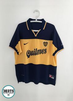 a shirt hanging on a wall with the name quillines written in gold and blue