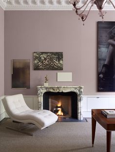 a living room filled with furniture and a fire place next to a painting on the wall