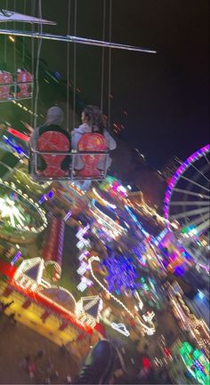 an amusement park at night with lights and rides