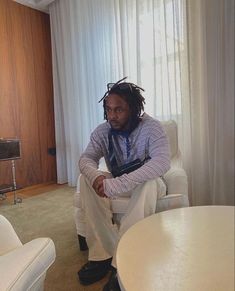 a man sitting on a white chair in a living room