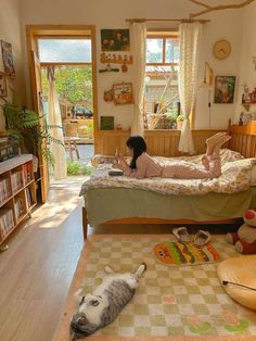 a woman laying on top of a bed in a bedroom next to a stuffed animal