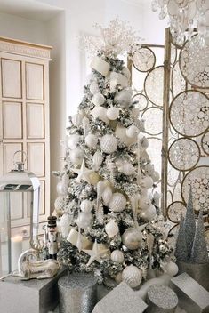 a white christmas tree with silver and white ornaments