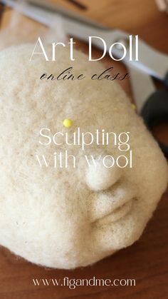 an art doll is made with wool and scissors on a wooden table next to it