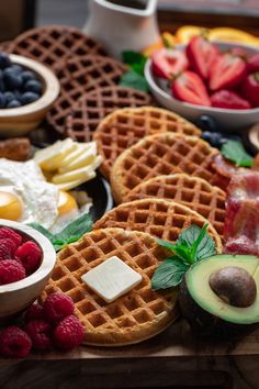 waffles, fruit and other foods are arranged on a table