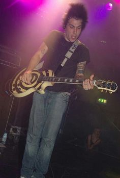 a young man playing an electric guitar on stage