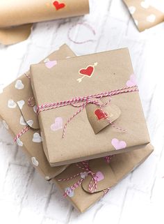 three wrapped gift boxes with hearts on them