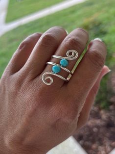 This beautiful Silver Wire Wrapped Ring is very elegant and specially designed to make you look gorgeous and to be a complement of that special outfit.  You can also give it as a anniversary gift or as an statement gift for your special girlfriend. It can also be part of the marvelous girls of your bridesmaids group.  This precious ring is made with a silver tone wire and a turquoise tone glass bead wrapped in a beautiful shape.  The tone of the wire can be changed. I T E M ~D E T A I L S  Mater Adjustable Wire Wrapped Sterling Silver Crystal Ring, Adjustable Sterling Silver Wire Wrapped Crystal Ring, Adjustable Wire Wrapped Open Ring, Elegant Wire Wrapped Toe Rings, Silver Wire Wrapped Crystal Promise Ring, Adjustable Silver Rings Hand Wrapped, Hand-wrapped Adjustable Silver Rings, Adjustable Hand Wrapped Silver Rings, Silver Spiral Wire Wrapped Rings