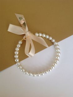 a white pearl necklace with a ribbon on it