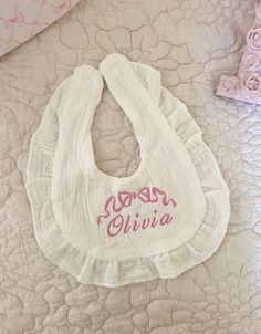 a baby bib with the word boss chivia on it sitting on top of a bed