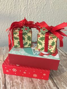 two wrapped presents sitting on top of a red box