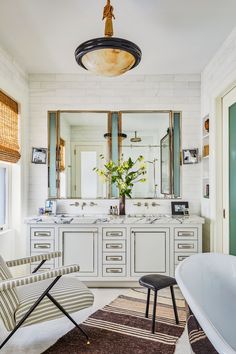 a bathroom with a tub, sink and large mirror above the bathtub is shown