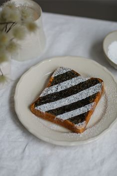 there is a piece of cake with black and white frosting on the plate next to it