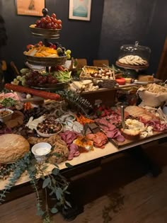 a table filled with lots of food on top of a wooden floor next to a wall