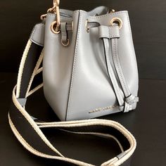 Marc Jacobs “The Bucket Bag” Handbag For Sale. Item Is New With Tags Nwt. The Bag Features Beautiful Neutral Gray Toned Leather Along With Polished Gold Hardware. The Bucket Style Bag Also Comes With An Adjustable Wide Crossbody Strap That Has Black, White, And Metallic Gold Threading. Item Comes With Dust Bag, Price Tag, And Additional Documents. Modern Bucket Bag With Branded Hardware For Travel, Tote Shaped Bucket Bag For Errands, Modern Bucket Bag With Branded Hardware For Daily Use, Chic Gray Shoulder Bag With Dust Bag, Gray Rectangular Shoulder Bag With Gold-tone Hardware, Modern Gray Bags With Detachable Handle, Modern Gray Bag With Detachable Handle, Gray Rectangular Bag With Gold-tone Hardware, Gray Leather Bag With Gold-tone Hardware