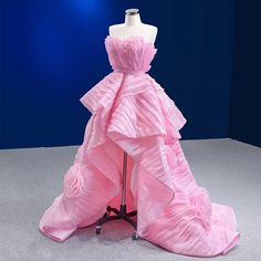 a pink dress is on display in front of a blue background