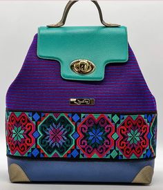 Loom and embroidered leather backpack.  Purple and blue horizontal loomed fabric cover the top half of the bag with a embroidered multi-colored patterned band across lower portion.  Top leather flap closure with classic twist fastner. Leather Hand strap as well as leather adjustable back straps.  Leather bottom.  Internal pocket: phone pocket, card/multifunctional pocket and coin pocket with zipper.    Dimensions: 30x36x13cm Bohemian Purple Shoulder Bag With Adjustable Strap, Backpack Purple, Artisan Bag, Bag Embroidery, Pocket Card, Embroidered Leather, Embroidery Bags, Hand Strap, Backpack Bag