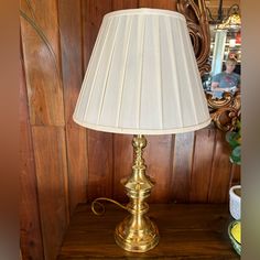 a gold lamp sitting on top of a wooden table