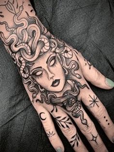 a woman's hand with tattoos on it