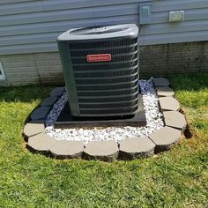 an air conditioner sitting in the grass next to a house