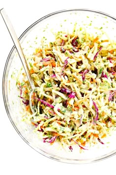 a bowl filled with coleslaw and carrots on top of a white table