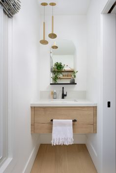 a bathroom with a sink, mirror and hanging lights