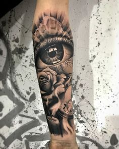 a man's arm with an eye and roses on it