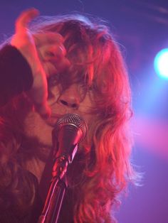 a woman singing into a microphone on stage