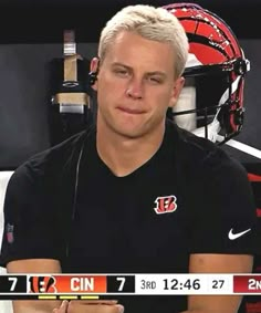 a man sitting in front of a football helmet