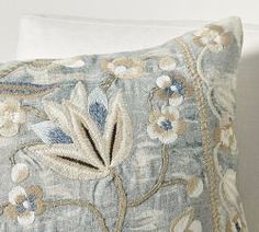 a blue and white pillow sitting on top of a bed