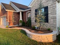 a brick house with landscaping in the front yard