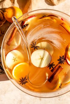 a glass filled with apple cider on top of a table