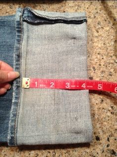 someone is measuring their jeans with a tape on the bottom and in the back pocket