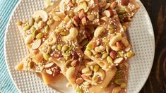 a white plate topped with pieces of cake covered in nuts