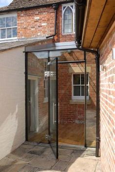 an outside view of a house with a glass door and brick building in the background