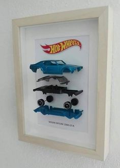 two hot wheels cars are in a shadow box on the wall next to each other