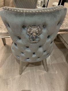 a grey chair with a lion head on it