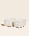 two white bowls sitting next to each other