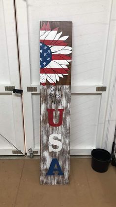 a wooden sign with an american flag and the word usa painted on it in red, white, and blue