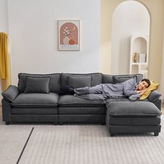 a man laying on top of a couch in a living room