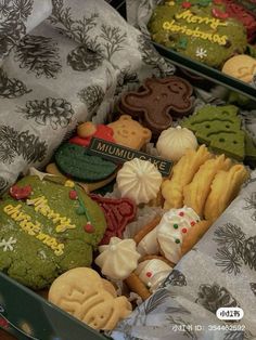 two boxes filled with assorted cookies on top of a table next to each other