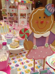 a table topped with lots of cupcakes and cake decor on top of it