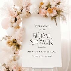 a welcome sign is surrounded by flowers and balloons for the bride's bridal shower